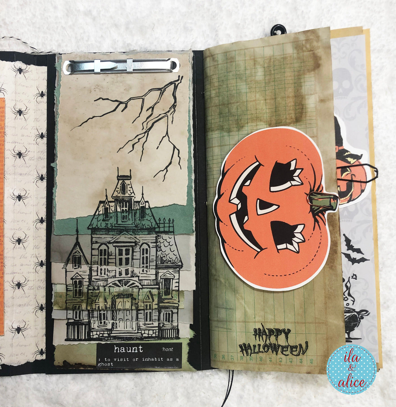 Open book with Halloween-themed pages featuring a haunted house and pumpkin.