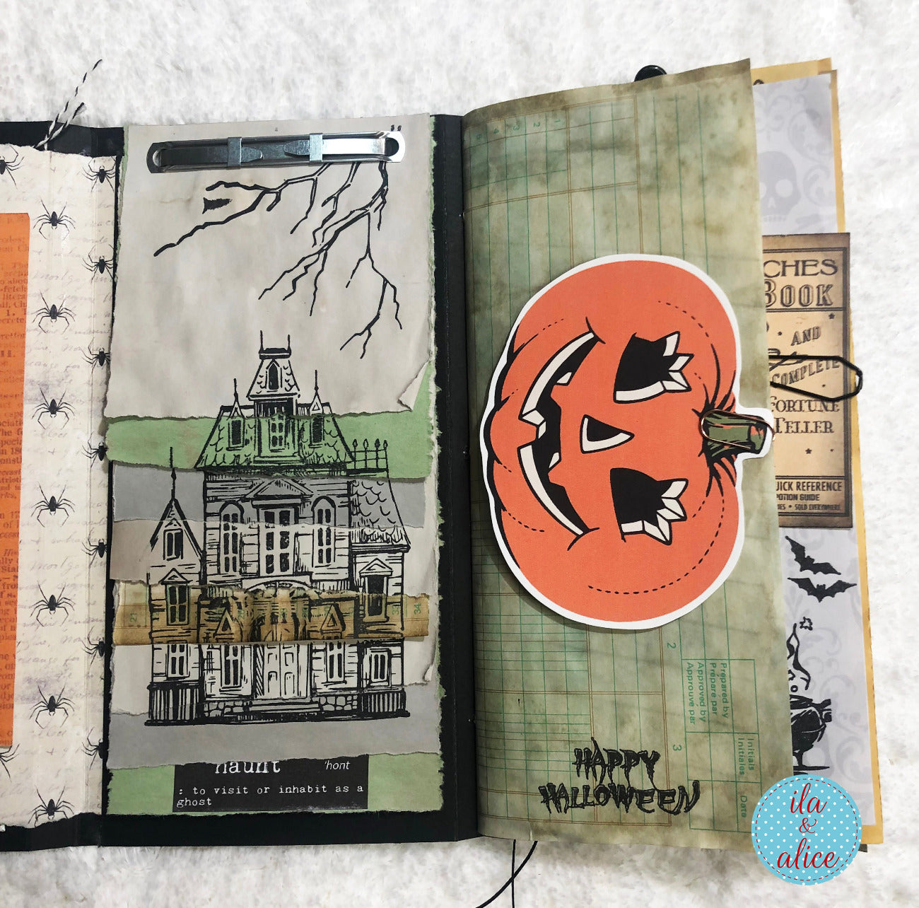 Open folio with Halloween-themed pages featuring a haunted house illustration and a pumpkin face.
