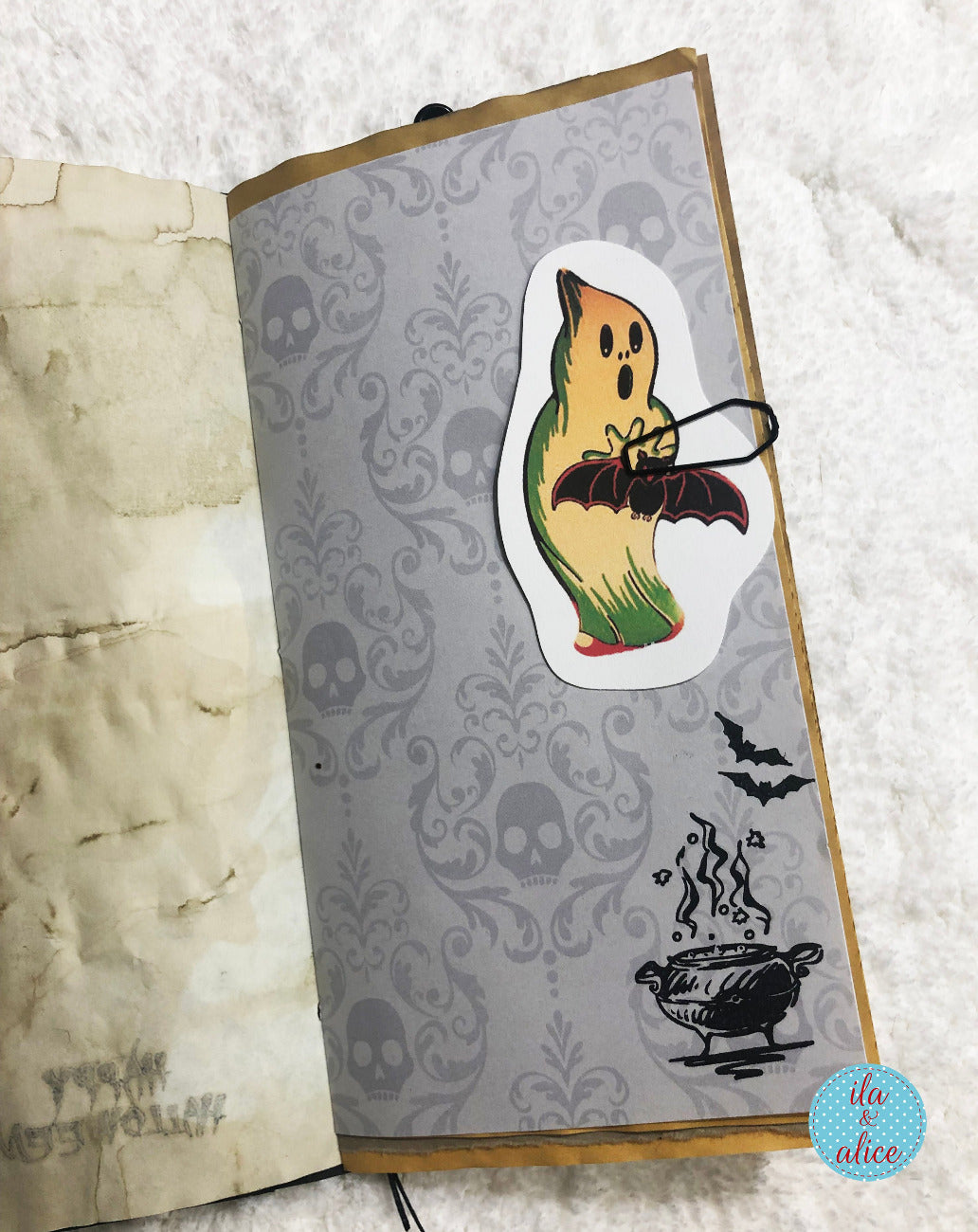 Decorative notebook with a ghost sticker on a skull and bat pattern