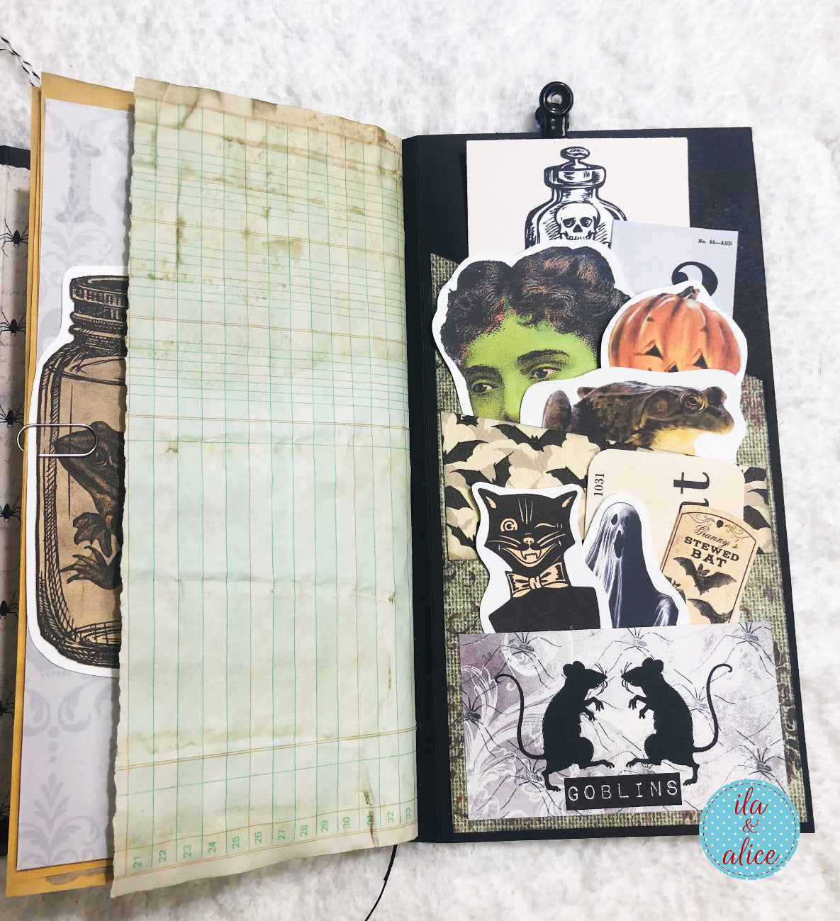 Open notebook with Halloween-themed ephemera on a textured surface