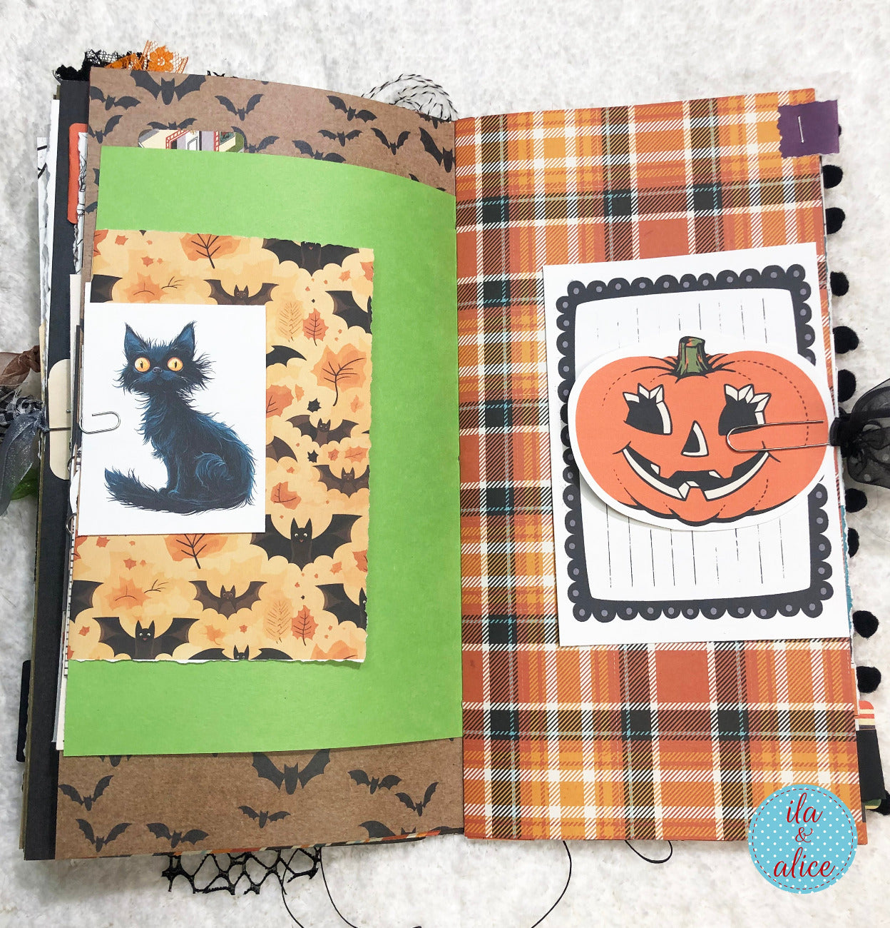 Handmade made Halloween junk journal with black cat and pumpkin designs on a textured surface.