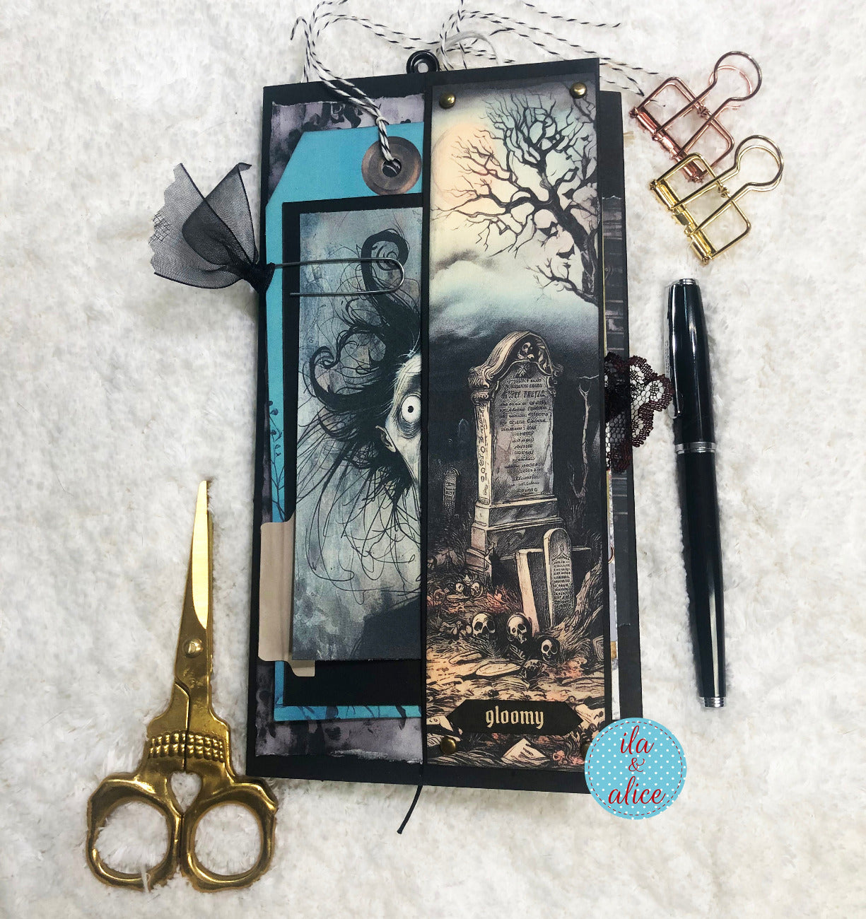 Gothic-themed folio with scissors, pen, and decorative elements on a textured surface