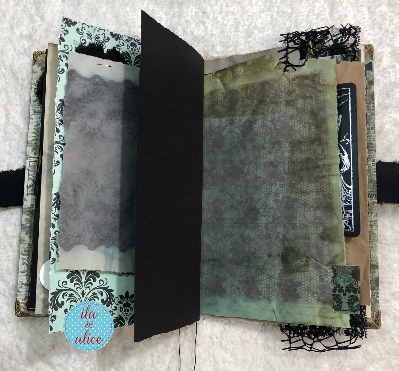 Handmade Eerie Halloween Gothic junk journal with textured pages and decorative elements on a textured surface