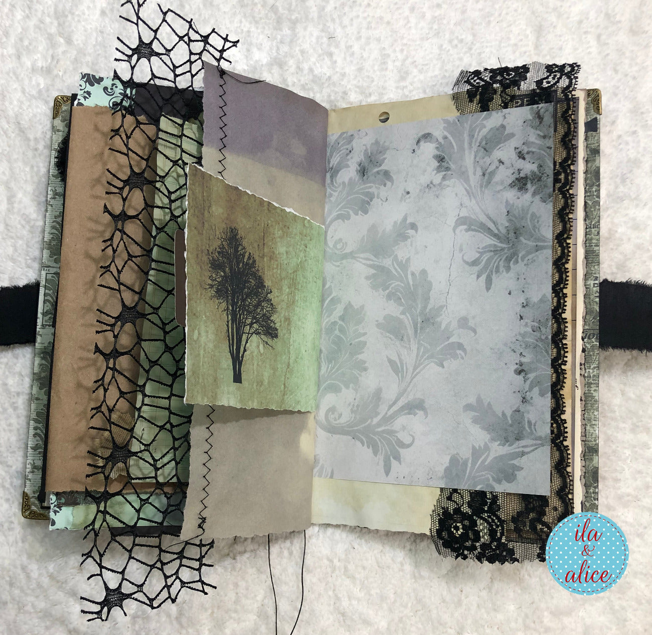 Handmade Eerie Halloween Gothic junk journal with textured papers and decorative elements on a textured surface.
