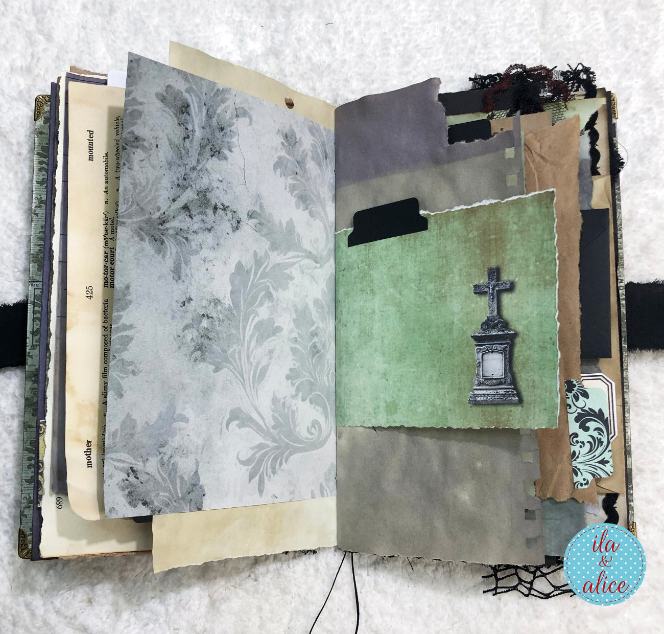 Handmade Eerie Halloween Gothic junk journal with textured pages and a gravestone illustration on a textured surface.