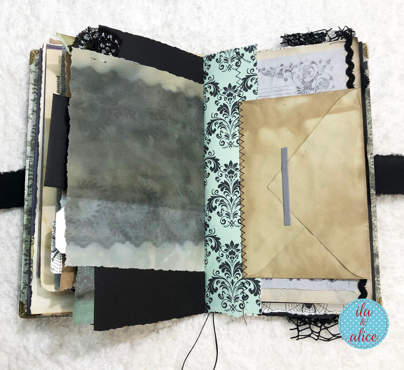 Handmade Eerie Halloween Gothic junk journal with decorative pages and a textured cover on a white background