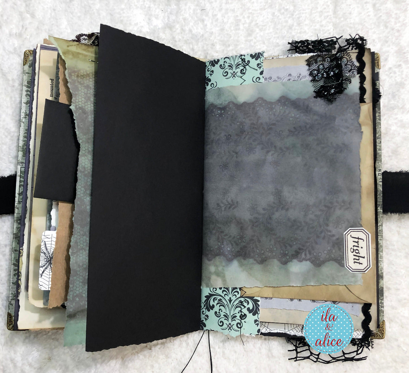 Handmade Eerie Halloween Gothic junk journal with textured pages and decorative elements on a white background