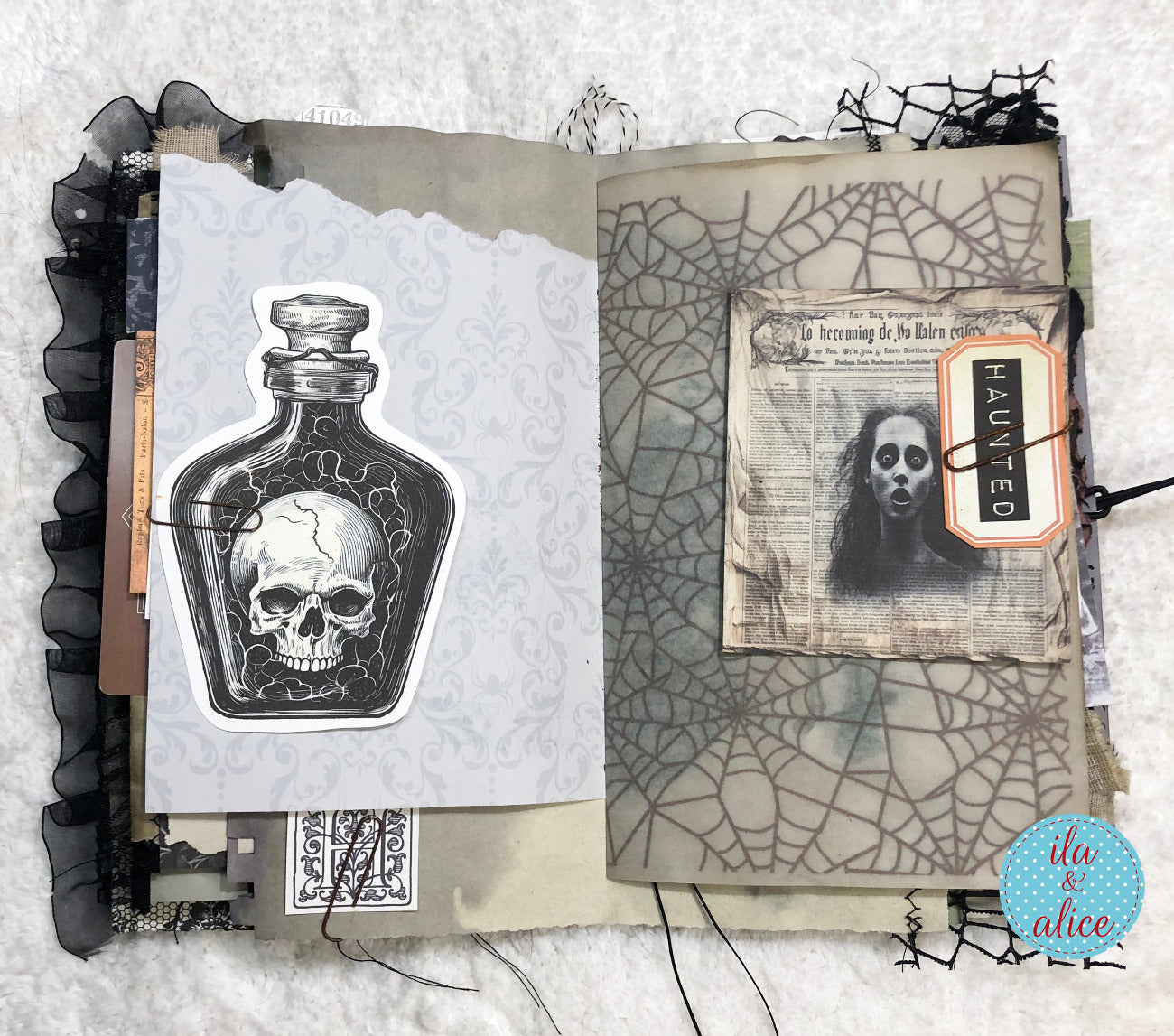 Gothic-style book with skull design and spider web pattern on a textured surface.