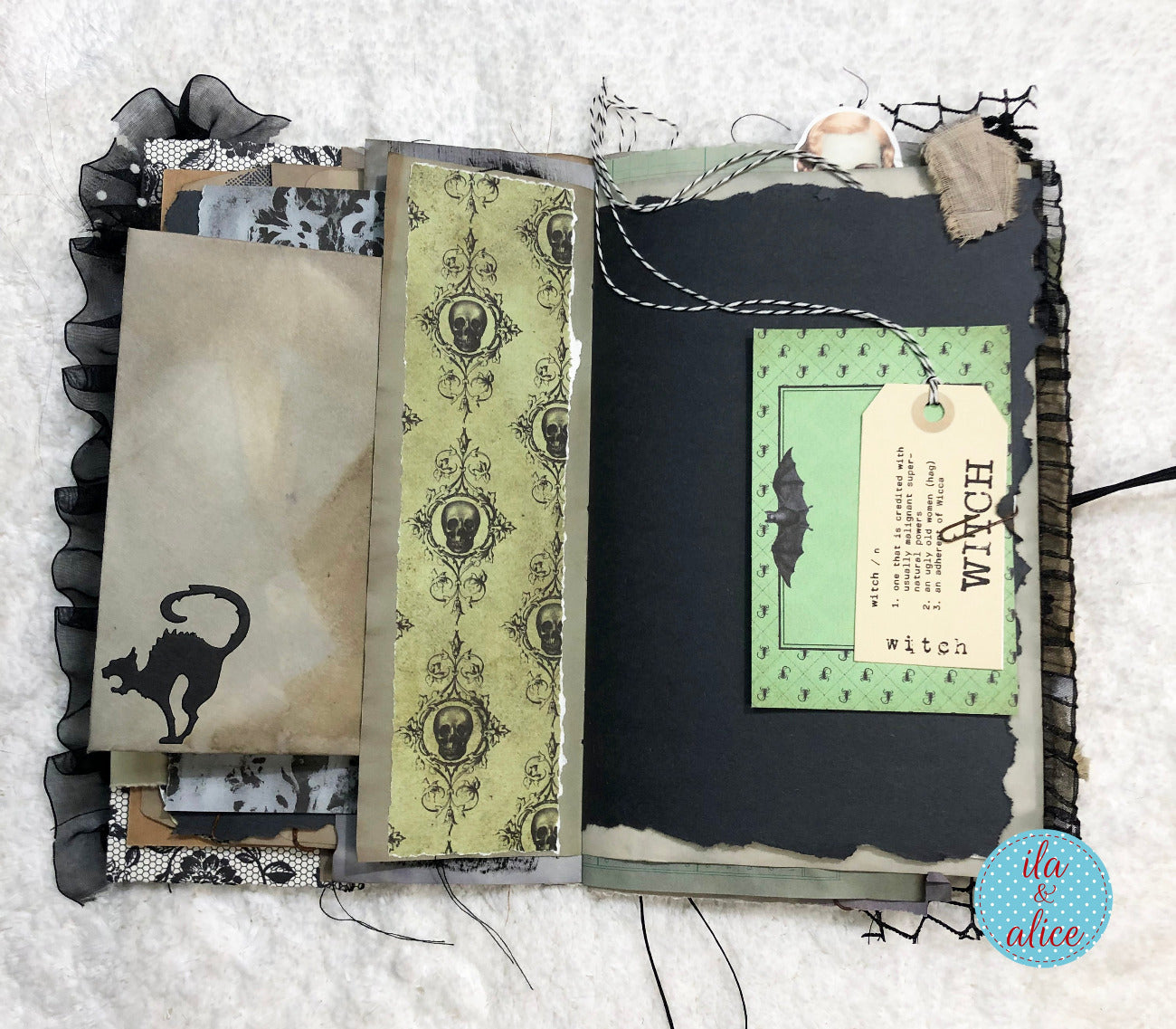 Handmade Halloween junk journal with black cat and green tags.