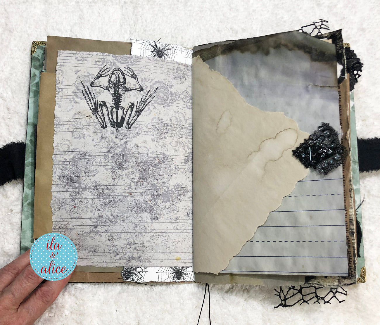 Handmade Eerie Halloween Gothic junk journal with skeleton hand illustration and textured pages on a white background