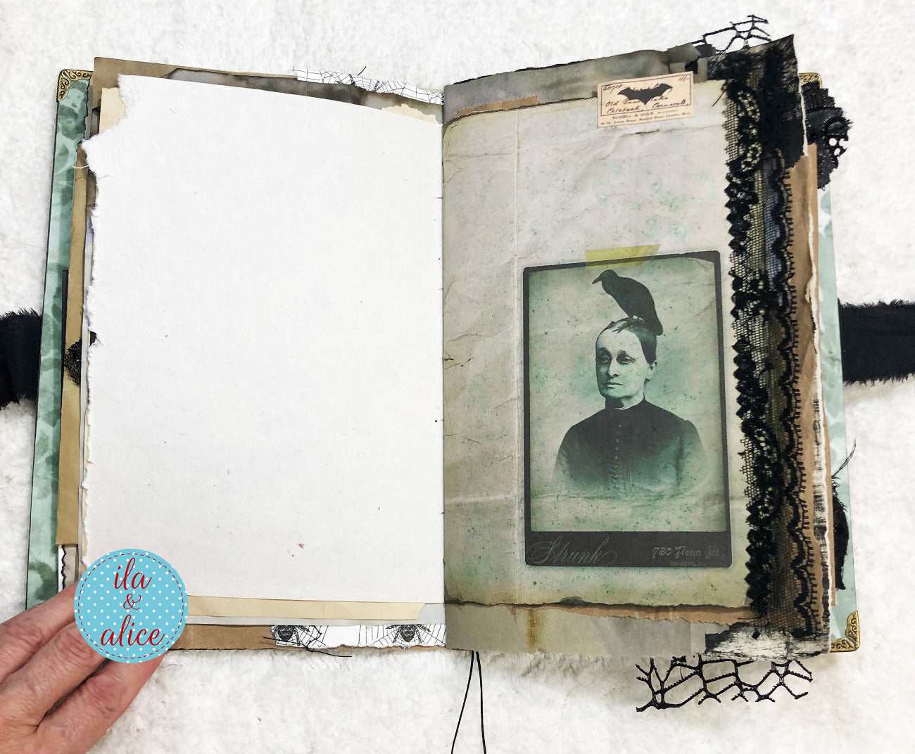 Handmade Eerie Halloween Gothic junk journal w vintage photo album with an old portrait inside, held by a hand.