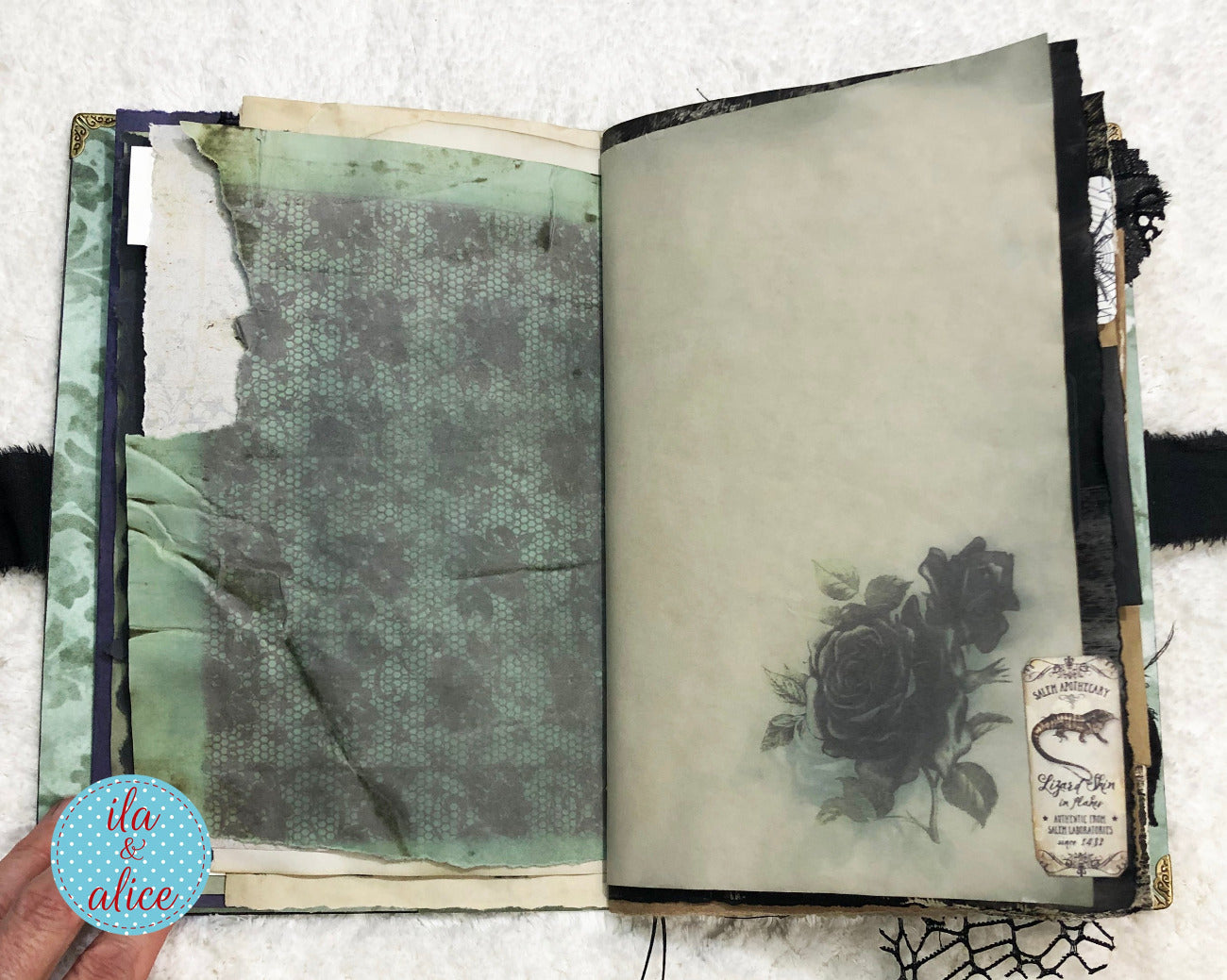 Handmade Eerie Halloween Gothic junk journal with decorative pages featuring a rose and text, on a textured white background.