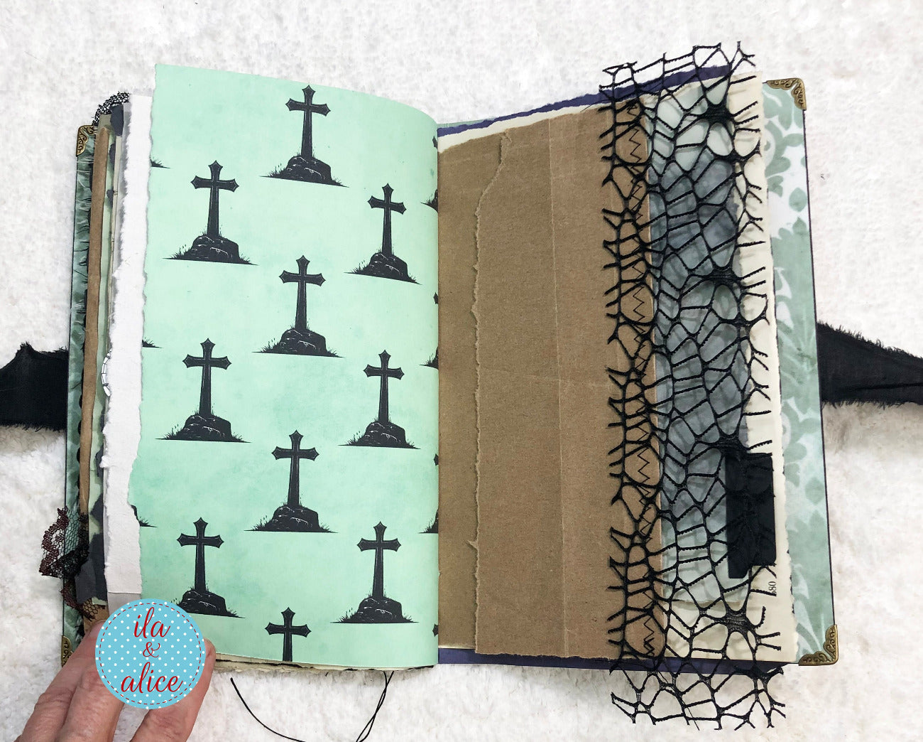 Handmade Eerie Halloween Gothic junk journal with green page featuring black cross patterns on a textured white background