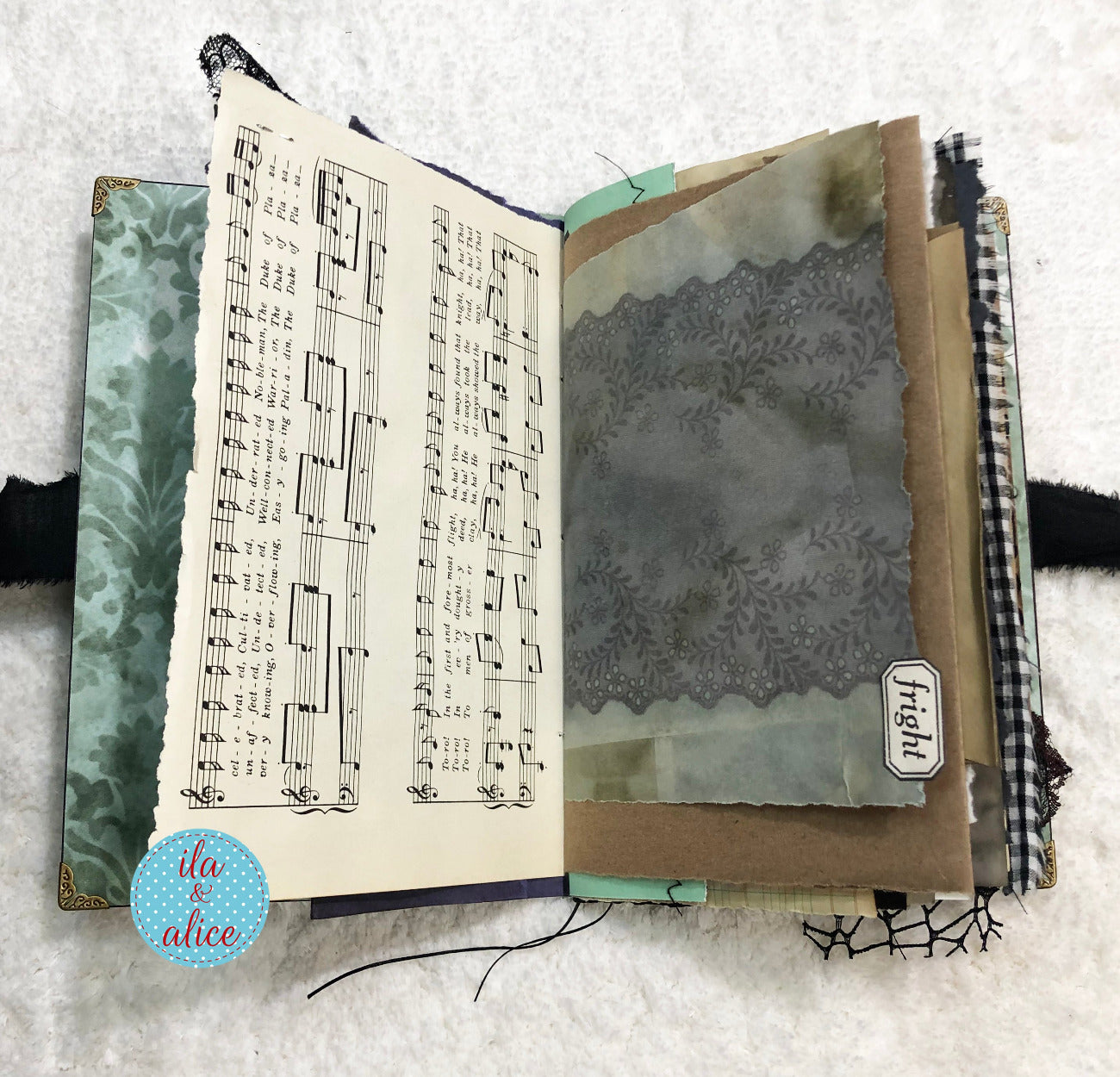 Handmade Eerie Halloween Gothic junk journal with music sheet and decorative pages on a textured surface