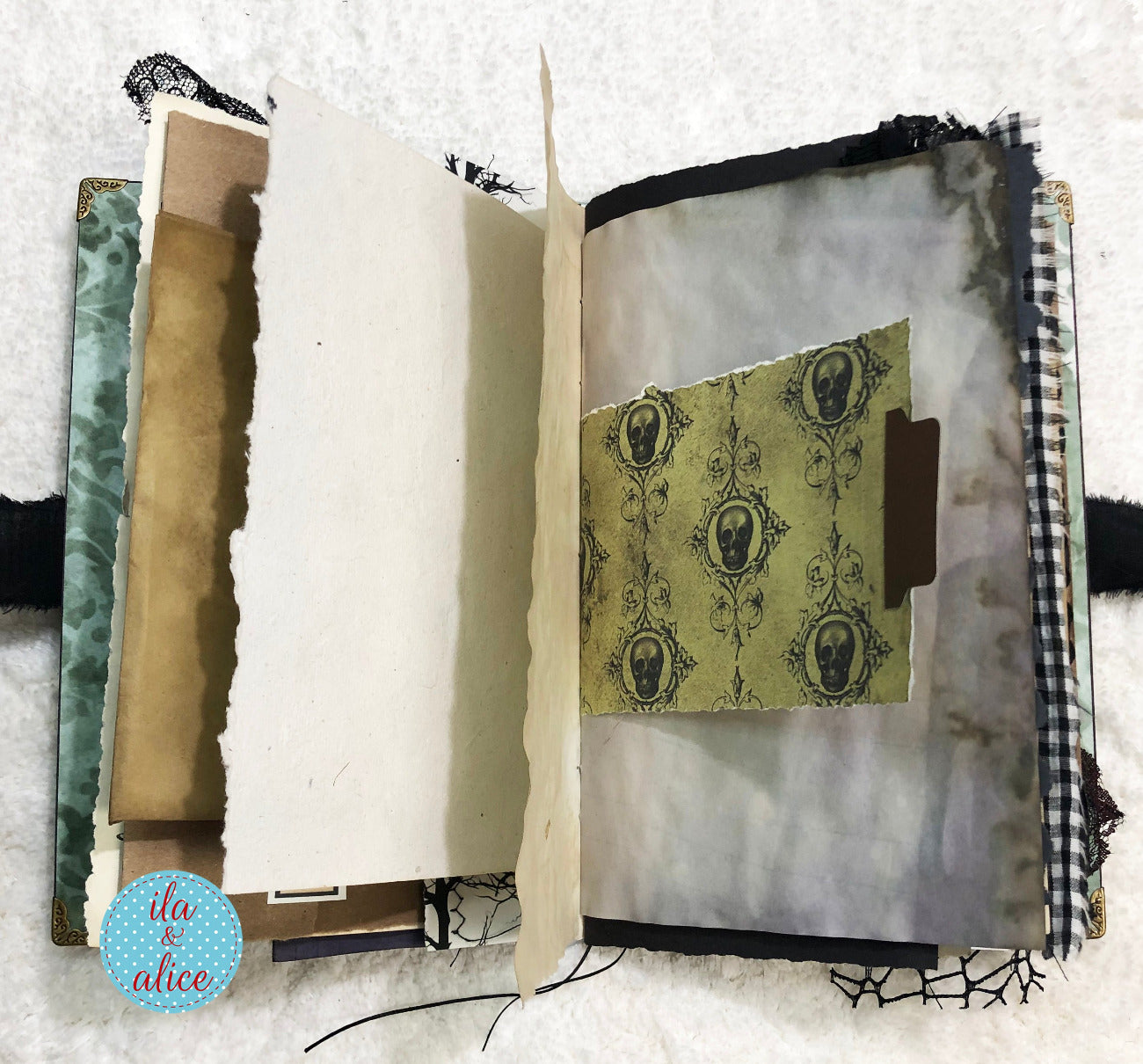 Handmade Eerie Halloween Gothic junk journal with decorative pages and a visible brand logo on a textured white background