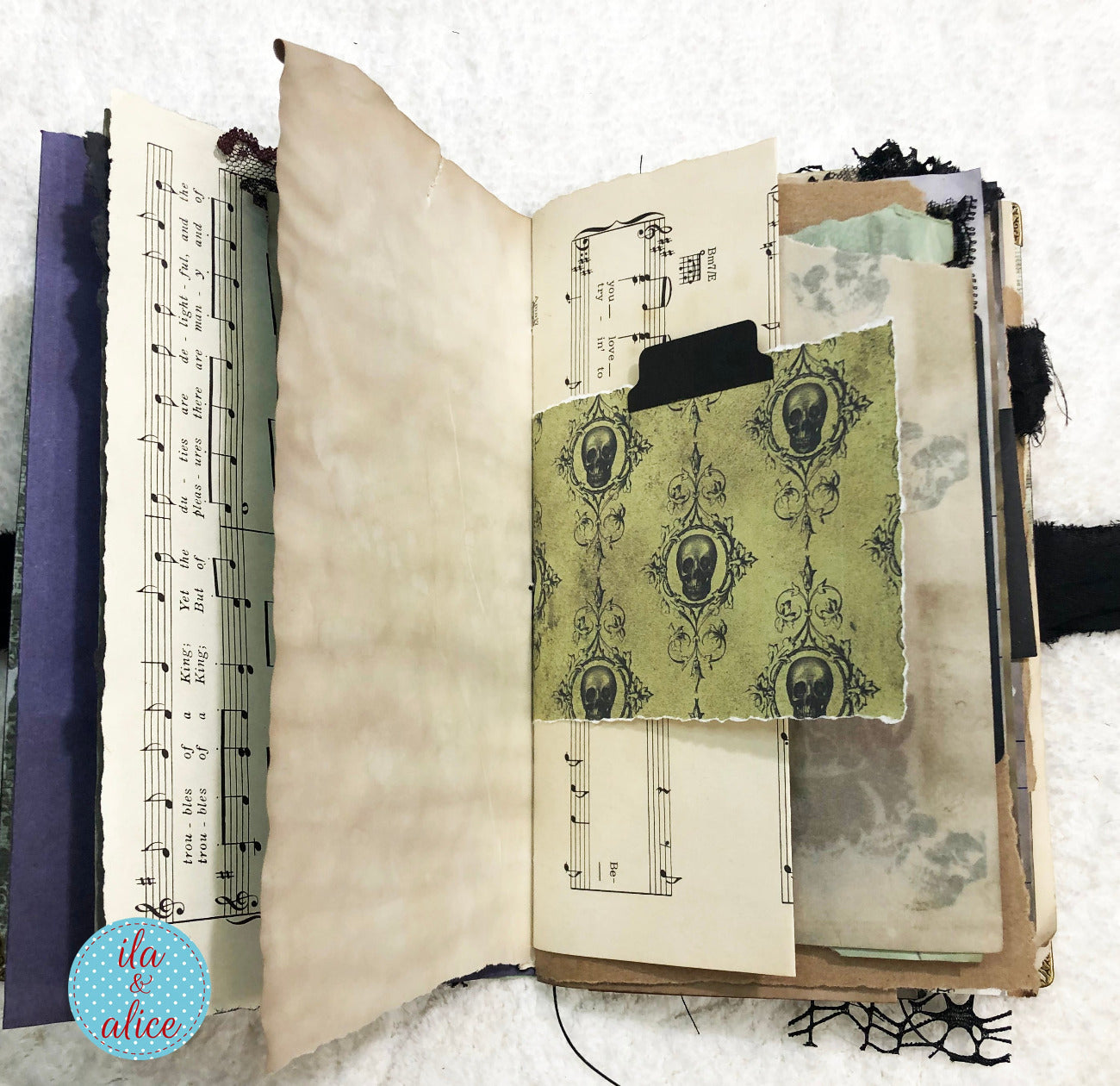 Handmade Eerie Halloween Gothic junk journal with vintage-style pages including sheet music and decorative text.