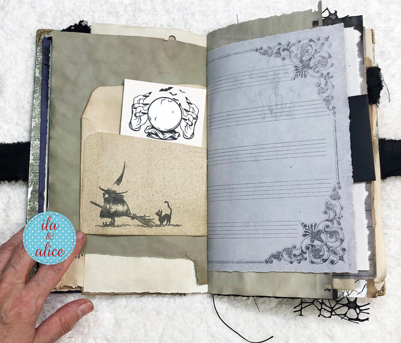 Handmade Eerie Halloween Gothic junk journal with decorative pages and a hand holding a small round object.