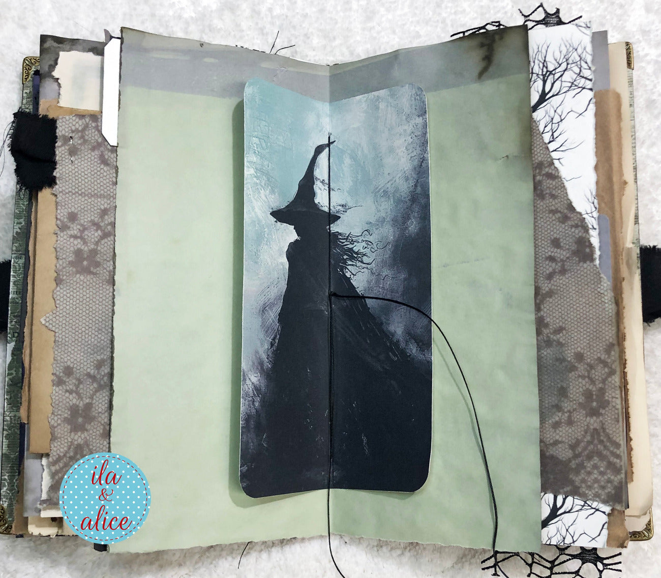 Handmade Eerie Halloween Gothic junk journal with a witch silhouette on a snowy background
