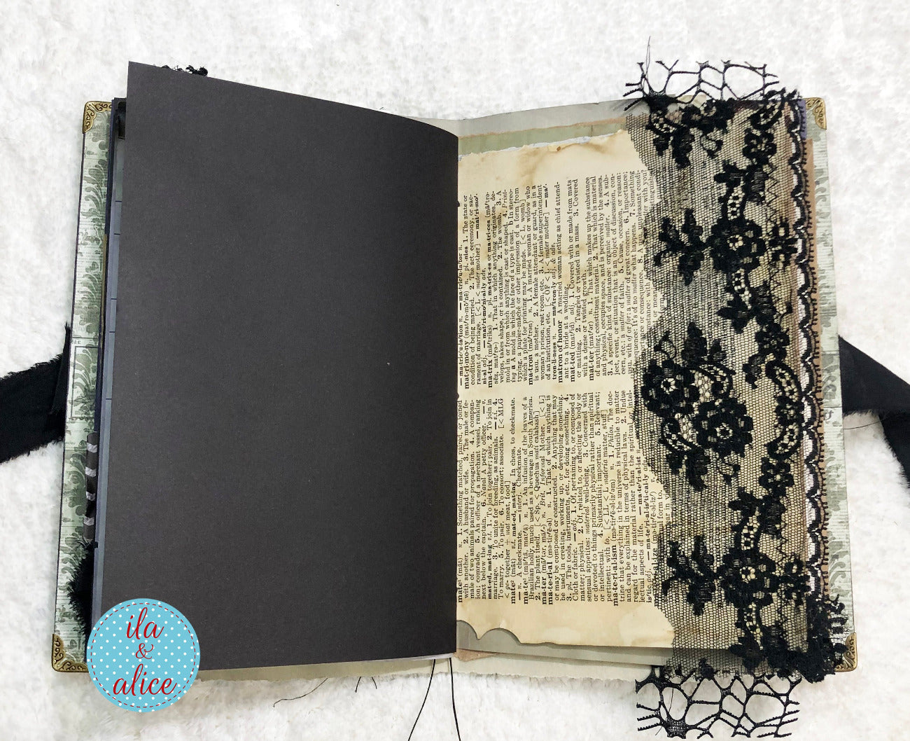 Handmade Eerie Halloween Gothic junk journal with black lace and text pages on a textured white background