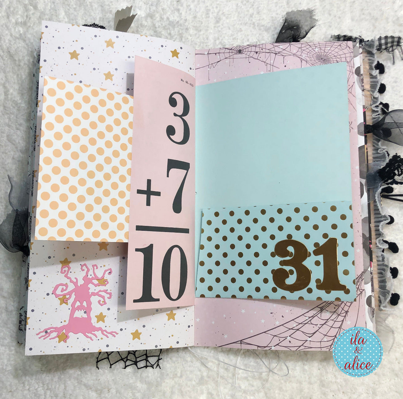 Handmade Pink and Black Halloween junk journal with numbers 10 and 31, and designs on a textured surface.