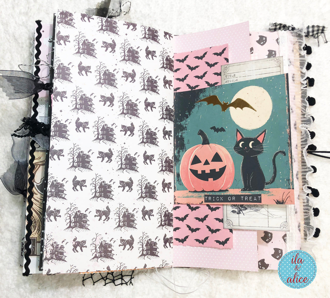Handmade Pink and Black Halloween junk journal with a pumpkin and black cat design on a textured surface.