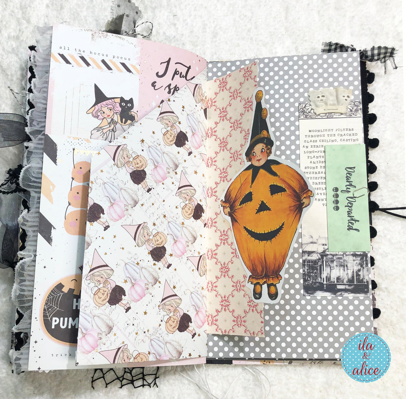 Handmade Pink and Black Halloween junk journal with pumpkins, witches, and ghosts on a textured surface.