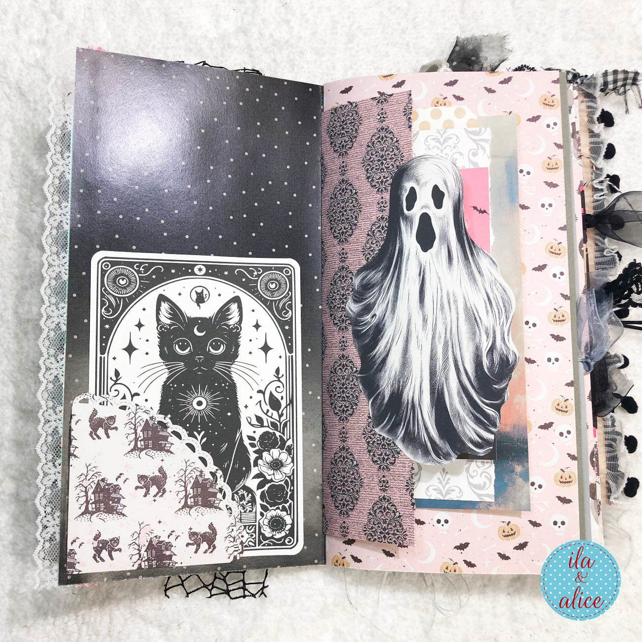 Handmade Pink and Black Halloween junk journal with black cat and ghost illustrations on decorative pages.