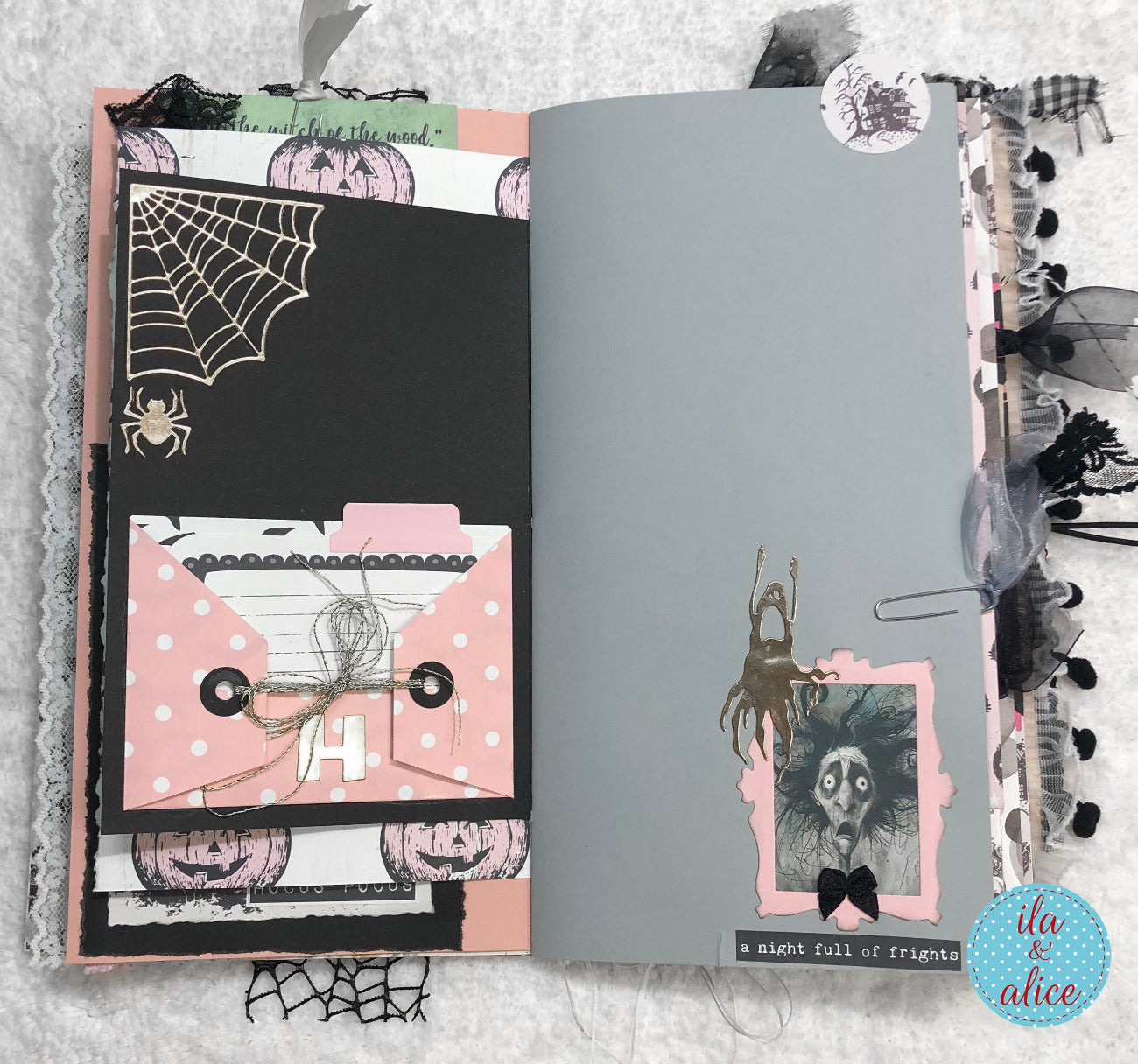 Handmade Pink and Black Halloween junk journal with Halloween-themed pages featuring pumpkins, spiders, and cobwebs.