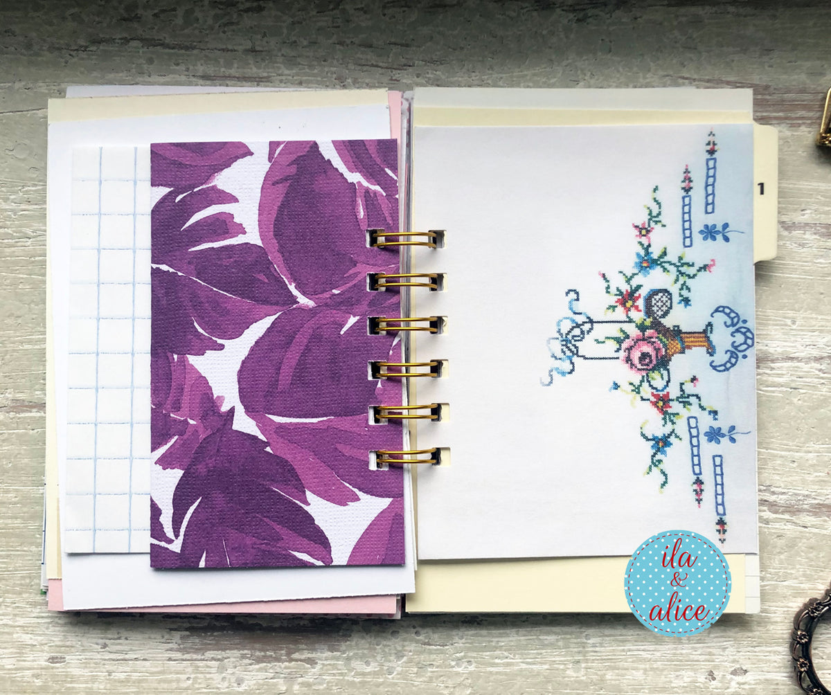 Open planner with floral and decorative cover on a wooden surface