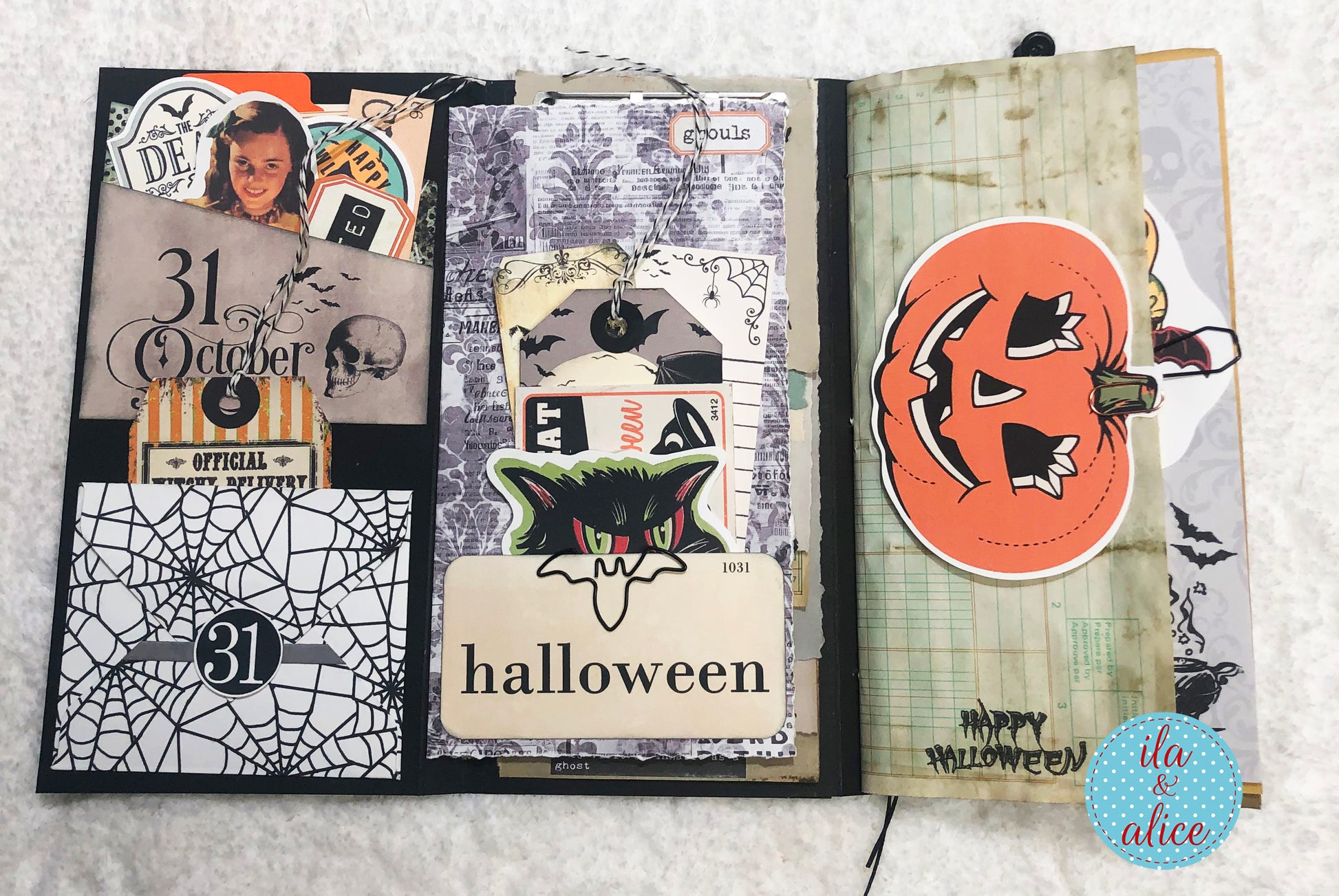 Open folio with Halloween-themed pages and stickers on a white background