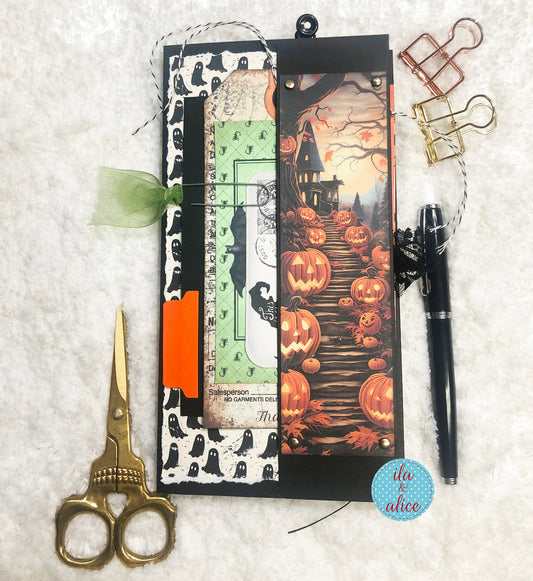 Halloween-themed folio with decorative scissors and pen on a textured surface