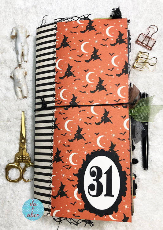 Handmade Halloween junk journal with witch designs and the number 31 on a textured surface.