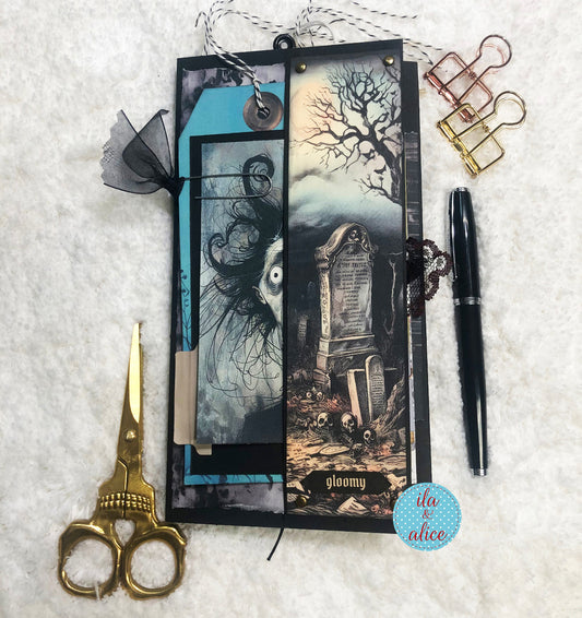 Gothic-themed folio with scissors, pen, and decorative elements on a textured surface