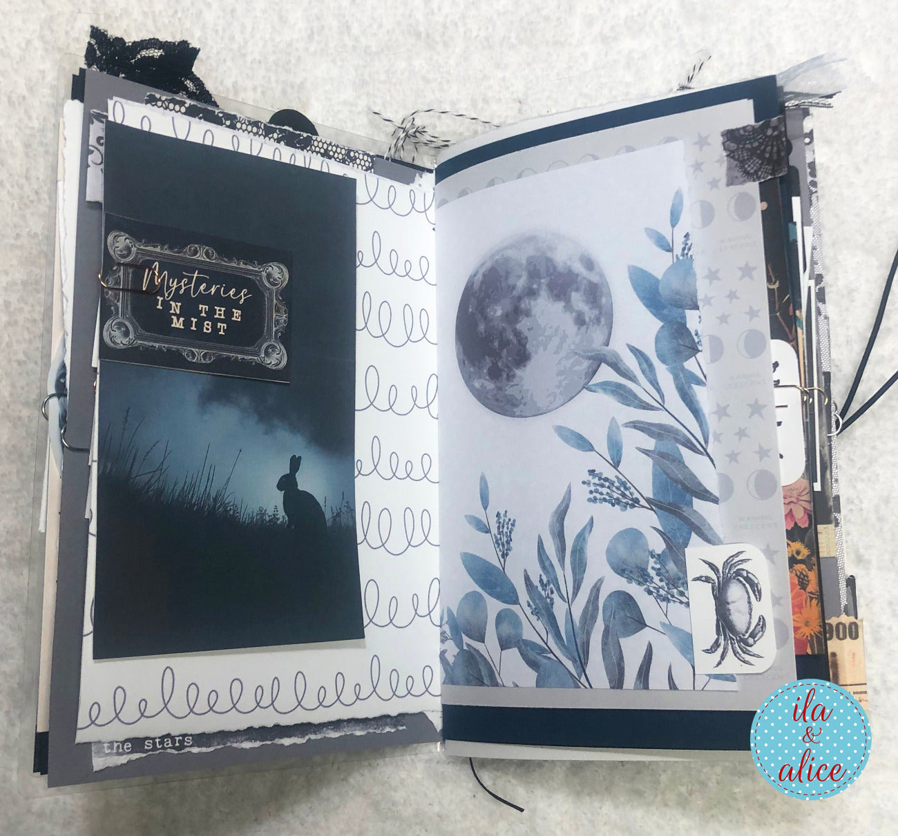 Handmade junk journal with full moon and hare, with decorative pages featuring moon and rabbit illustration, text, and floral design.