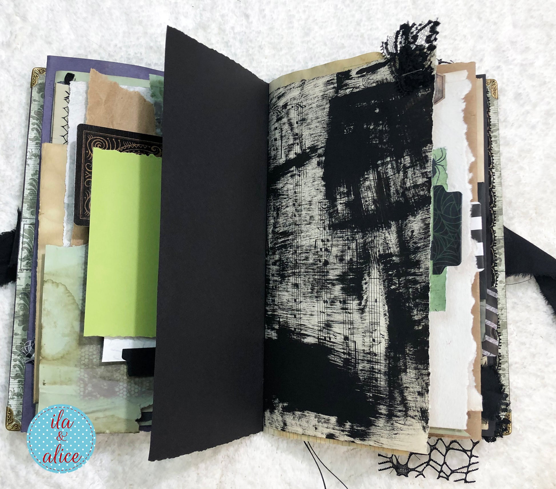 Handmade Eerie Halloween Gothic junk journal with textured pages and a black cover on a textured surface