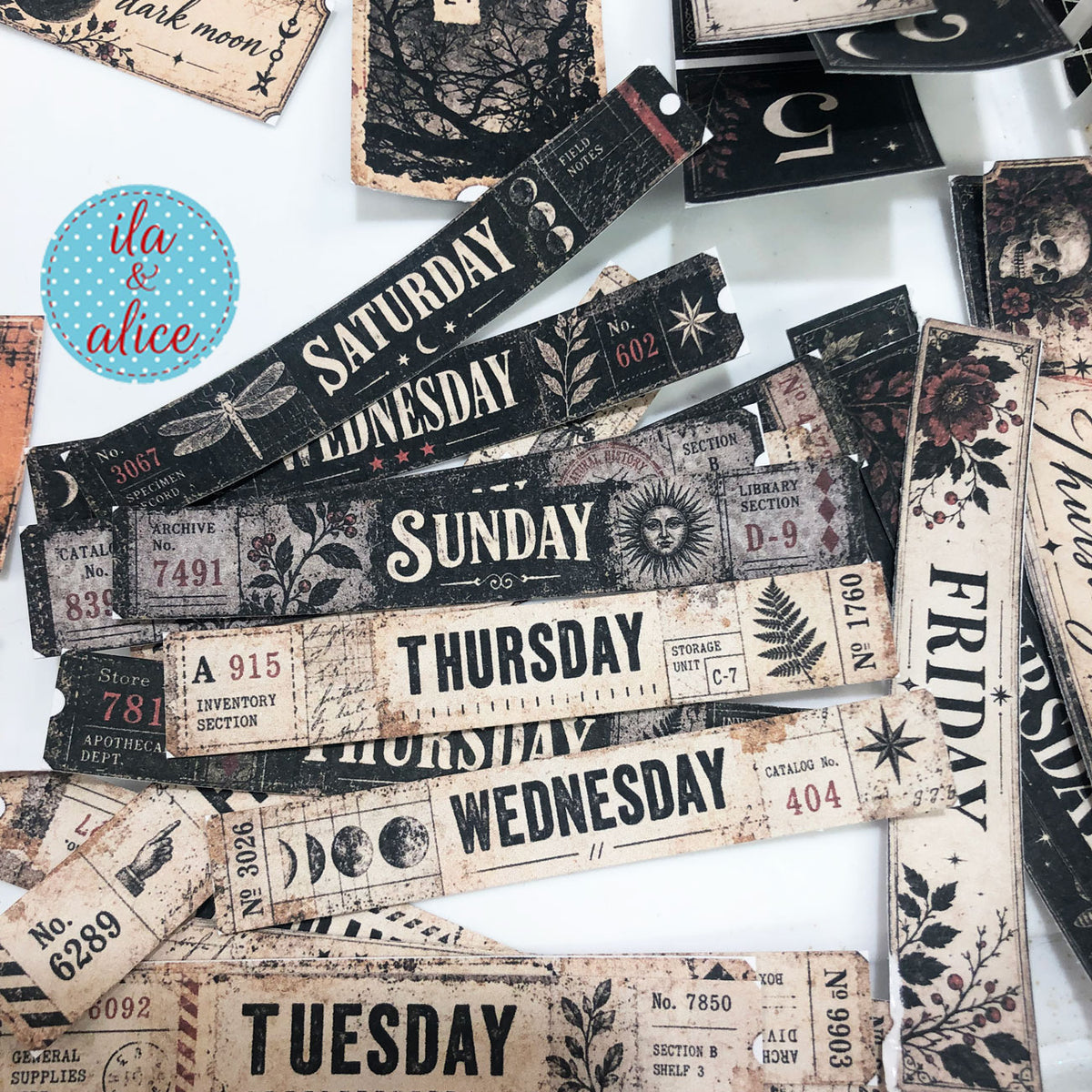 Assorted cut gothic weekday strips from the Midnight Findings printable kit arranged on a work surface.