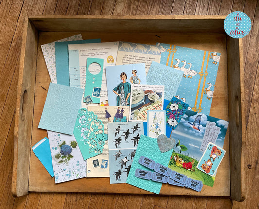 Curated 8x12 junk journal ephemera pack with layered papers, botanical elements, and tuck-able pieces. Blue theme.