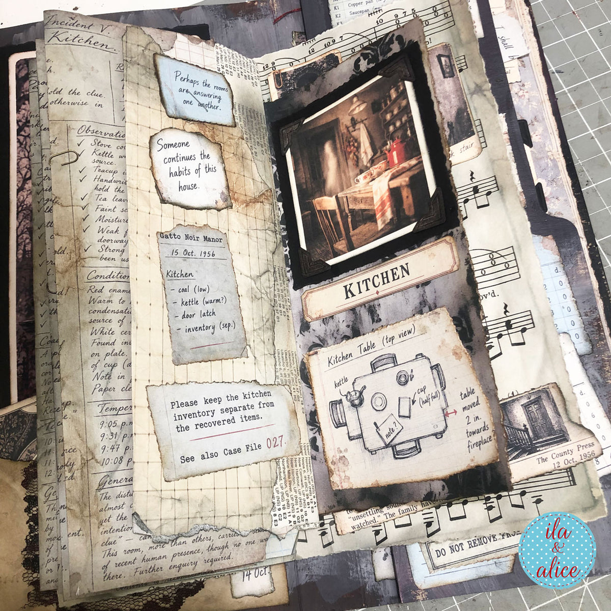 Gatto Noir Manor journal spread with handwritten notes, kitchen photograph and floor plan