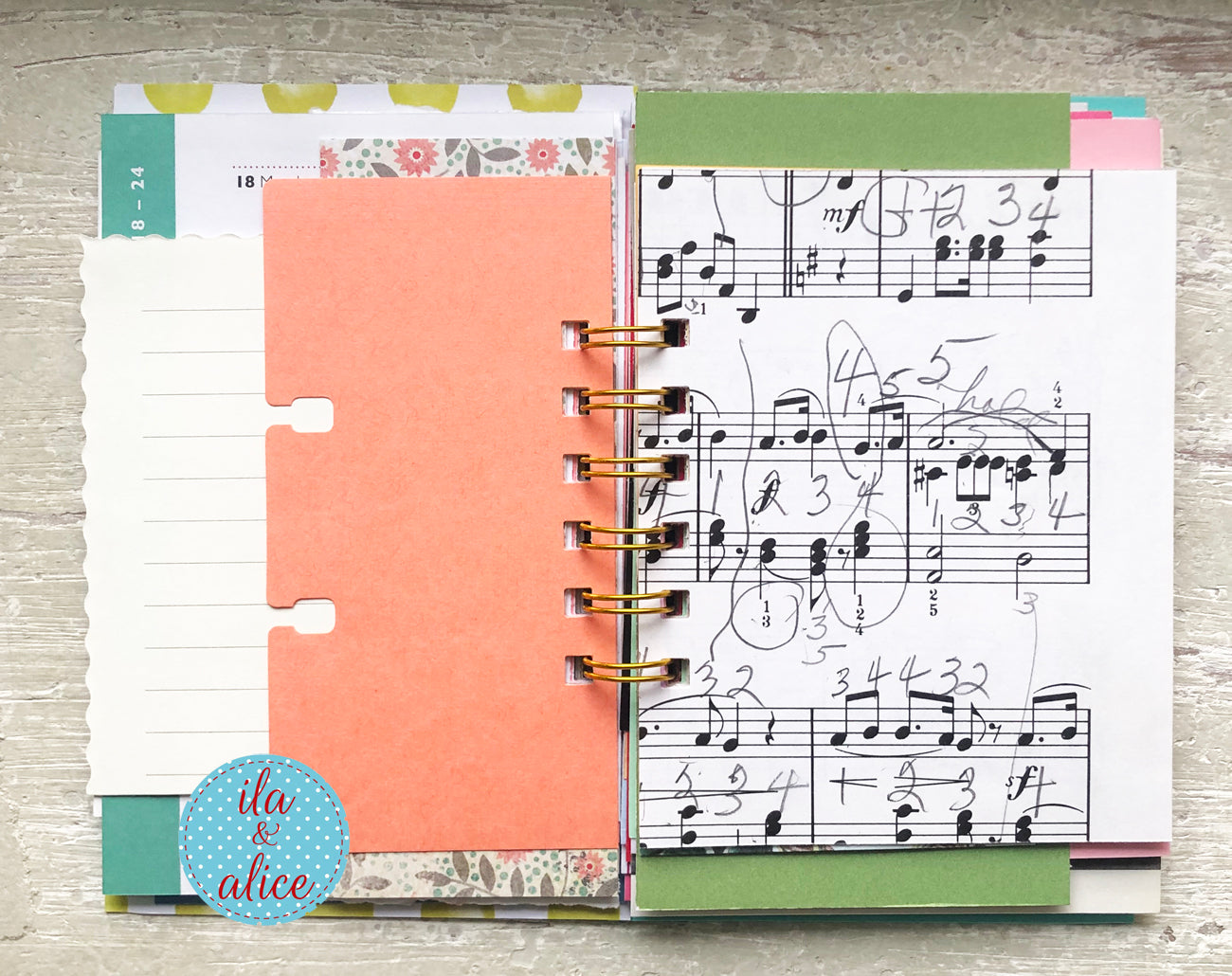 Notebook with music sheet and planner pages on a wooden surface, featuring 'ila & alice' branding.