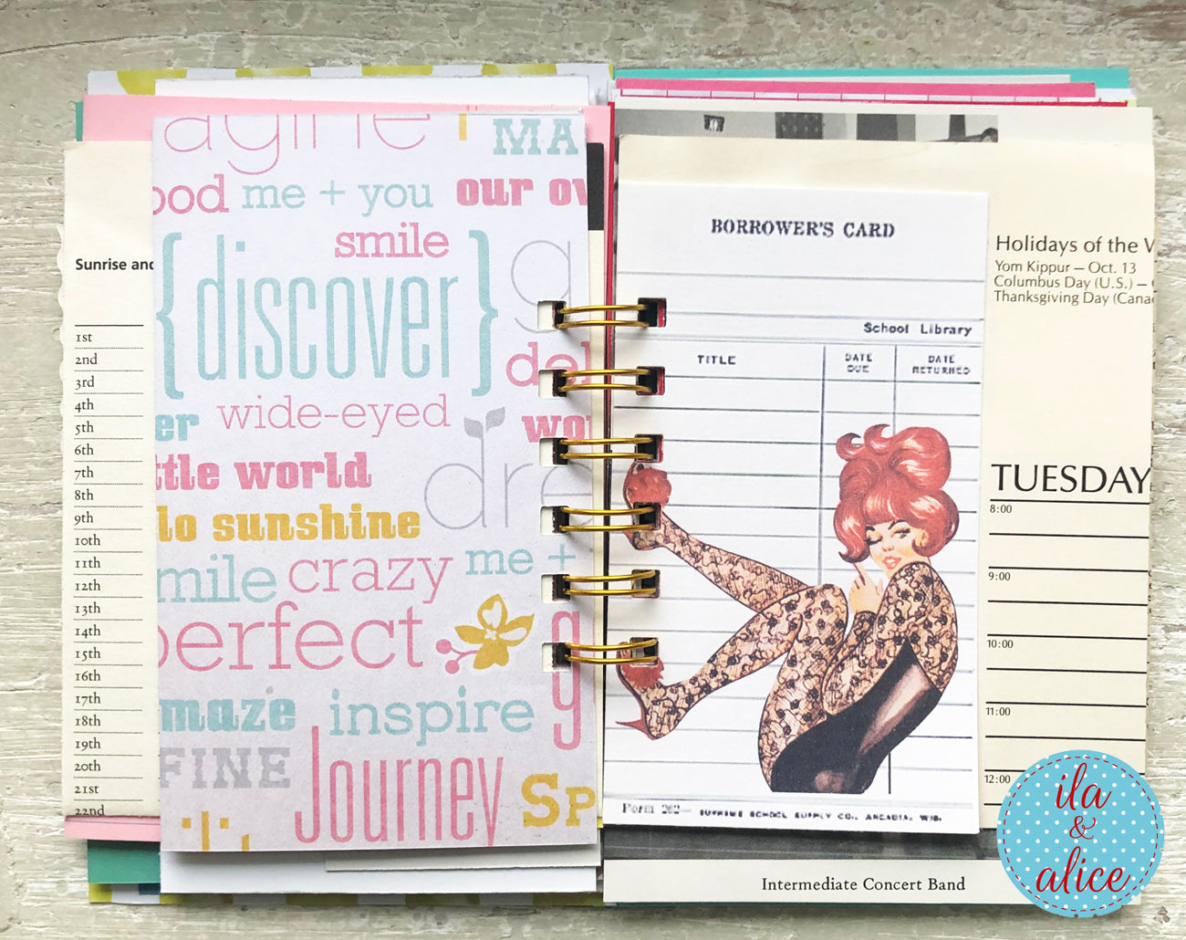Planner with colorful text pages and a vintage-style illustration on a wooden surface.