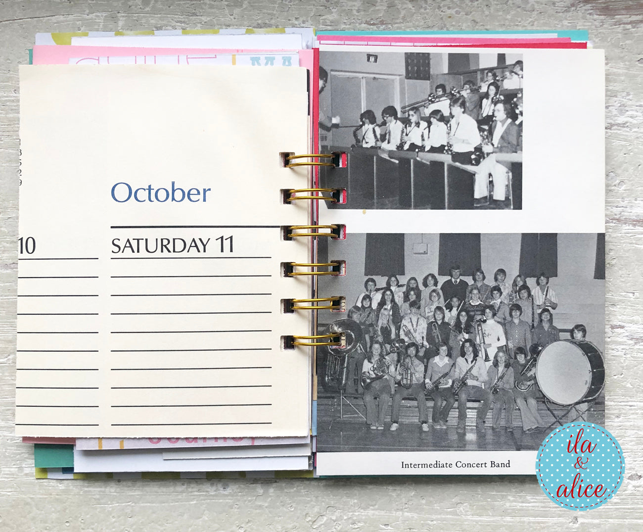 Open planner showing a page with a photo of a band and text, on a wooden surface.