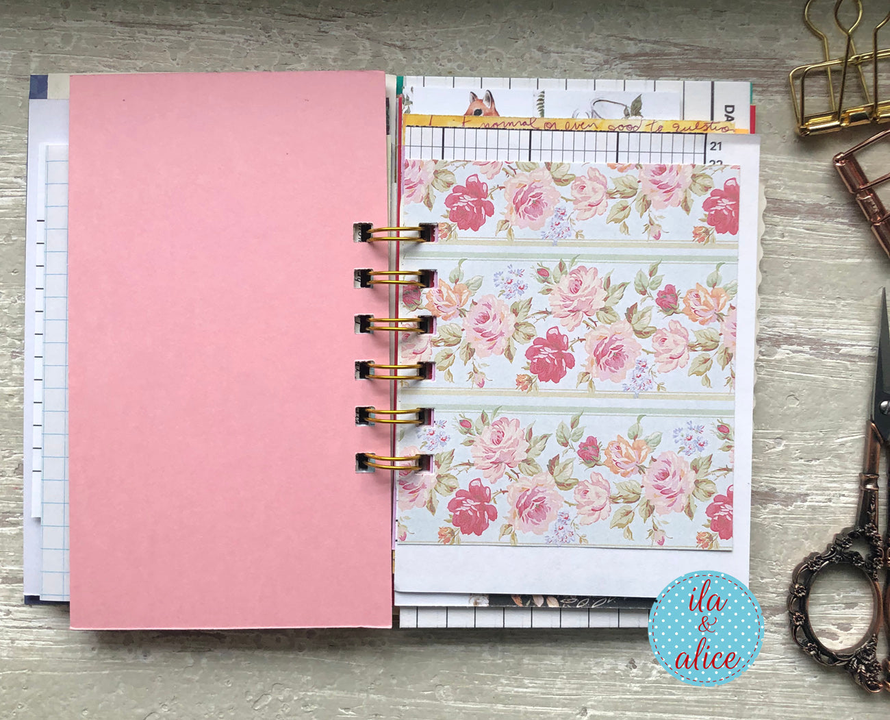 Planner with floral design on a wooden surface, featuring the brand 'ila & alice'.