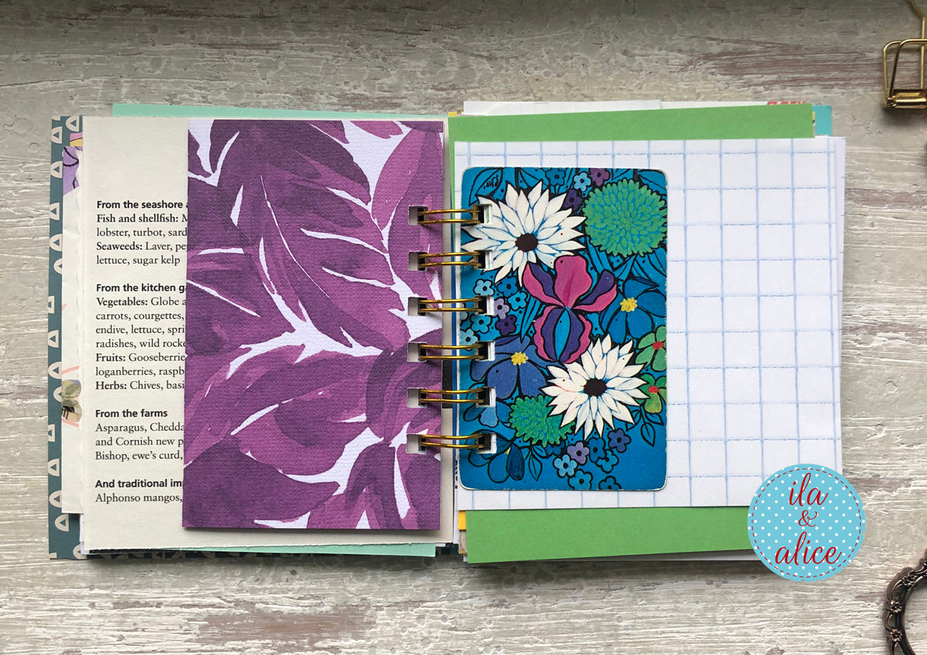 Open planner with floral and leaf designs on a wooden surface