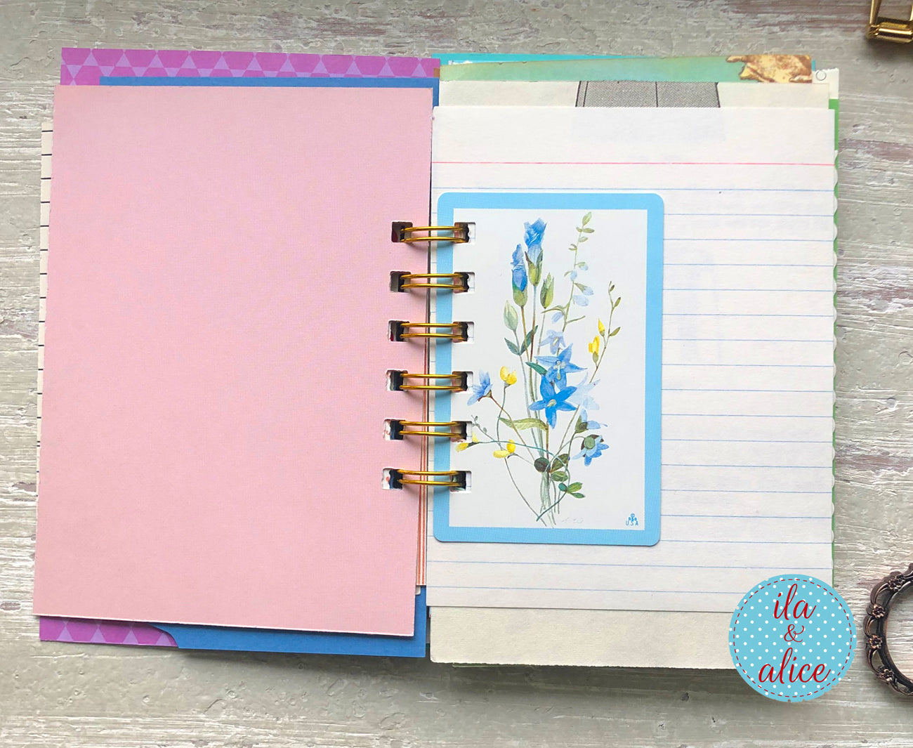 Planner with pink cover and floral design on a wooden surface