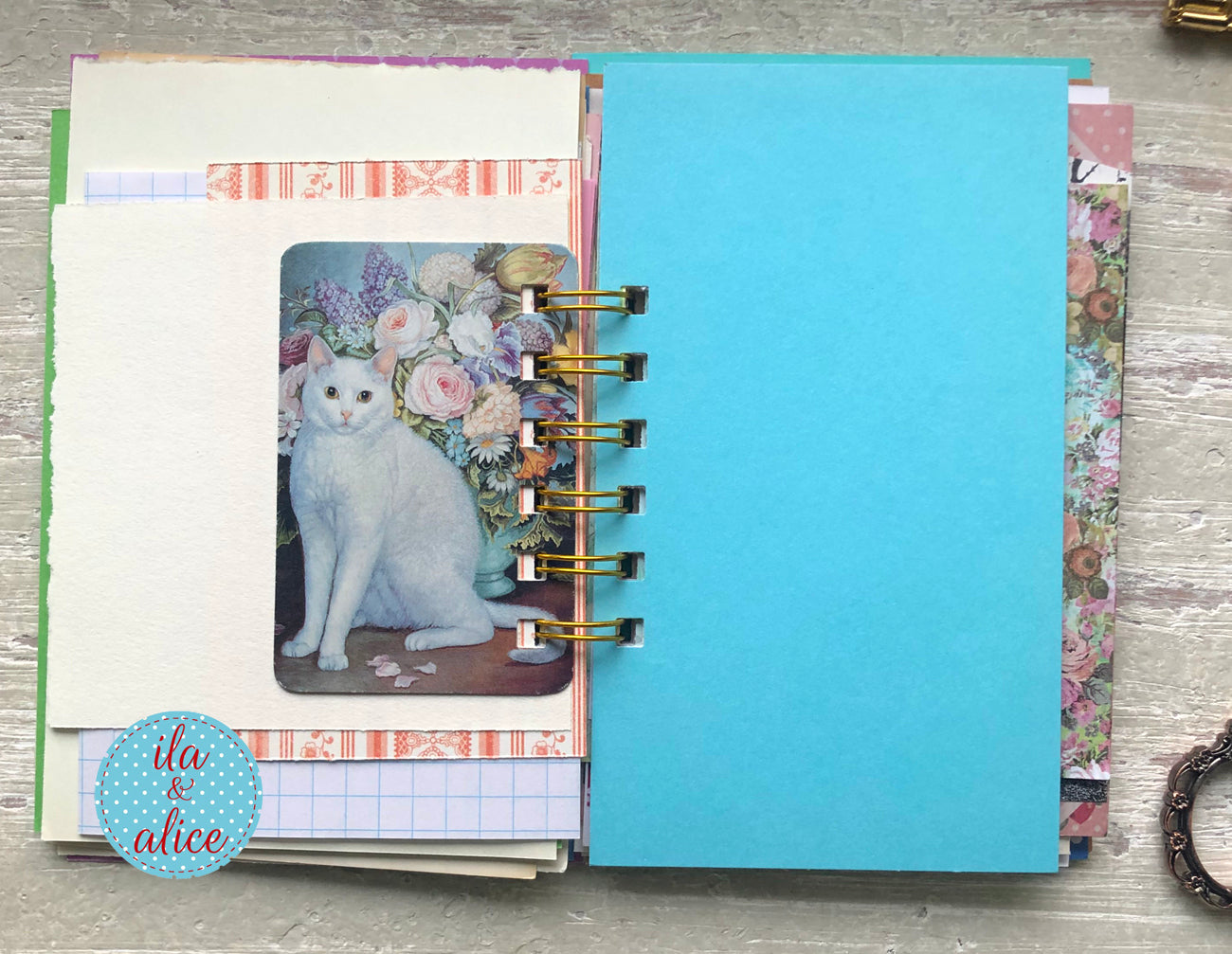 Open planner with floral design and cat illustration on a wooden surface