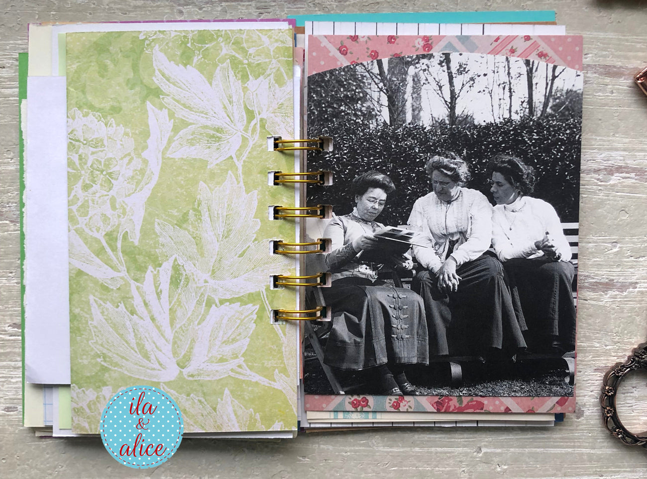 Scrapbook page with vintage photo of three women sitting on a bench, surrounded by patterned paper and decorative elements.