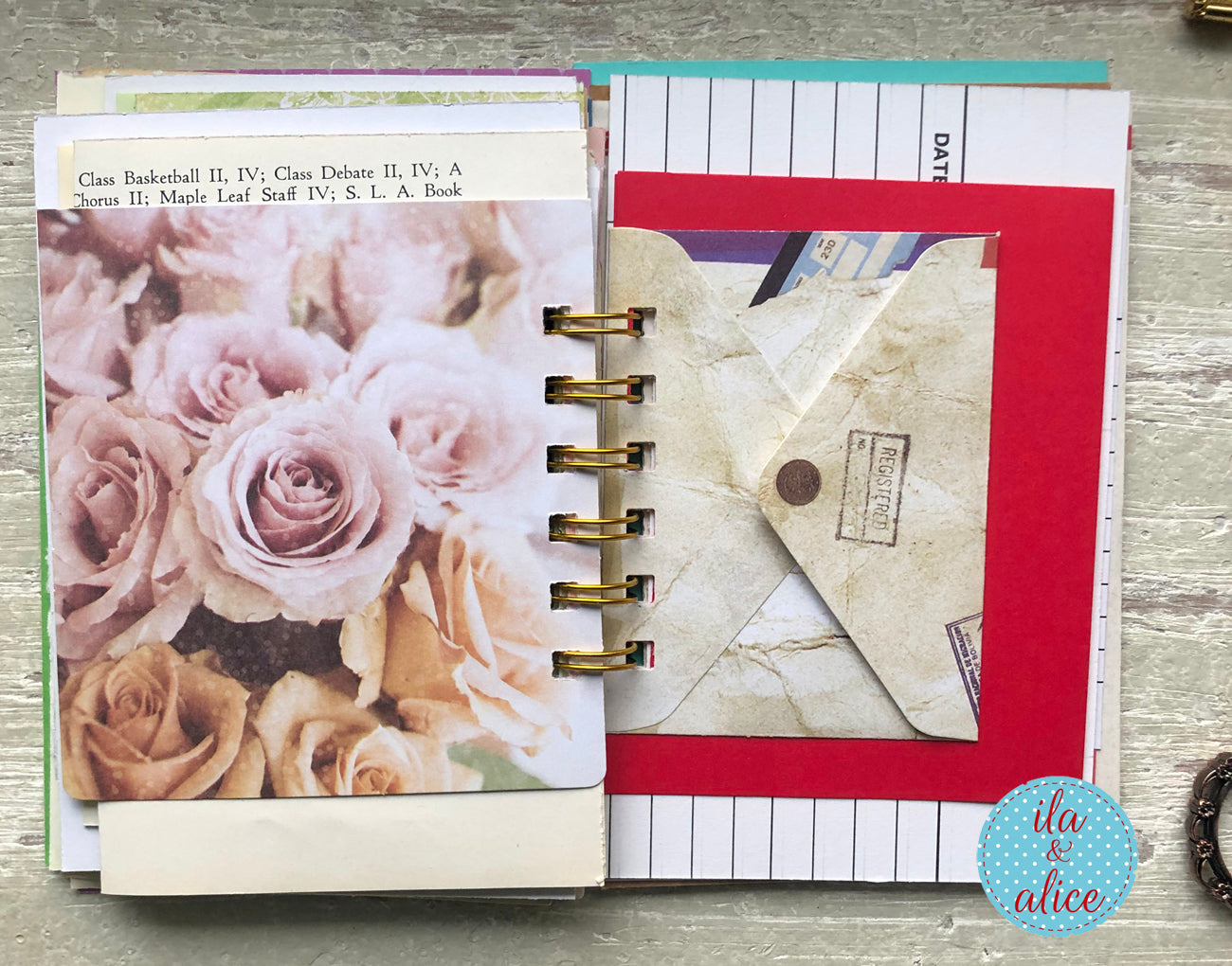 Planner with floral cover and stationery items on a wooden surface