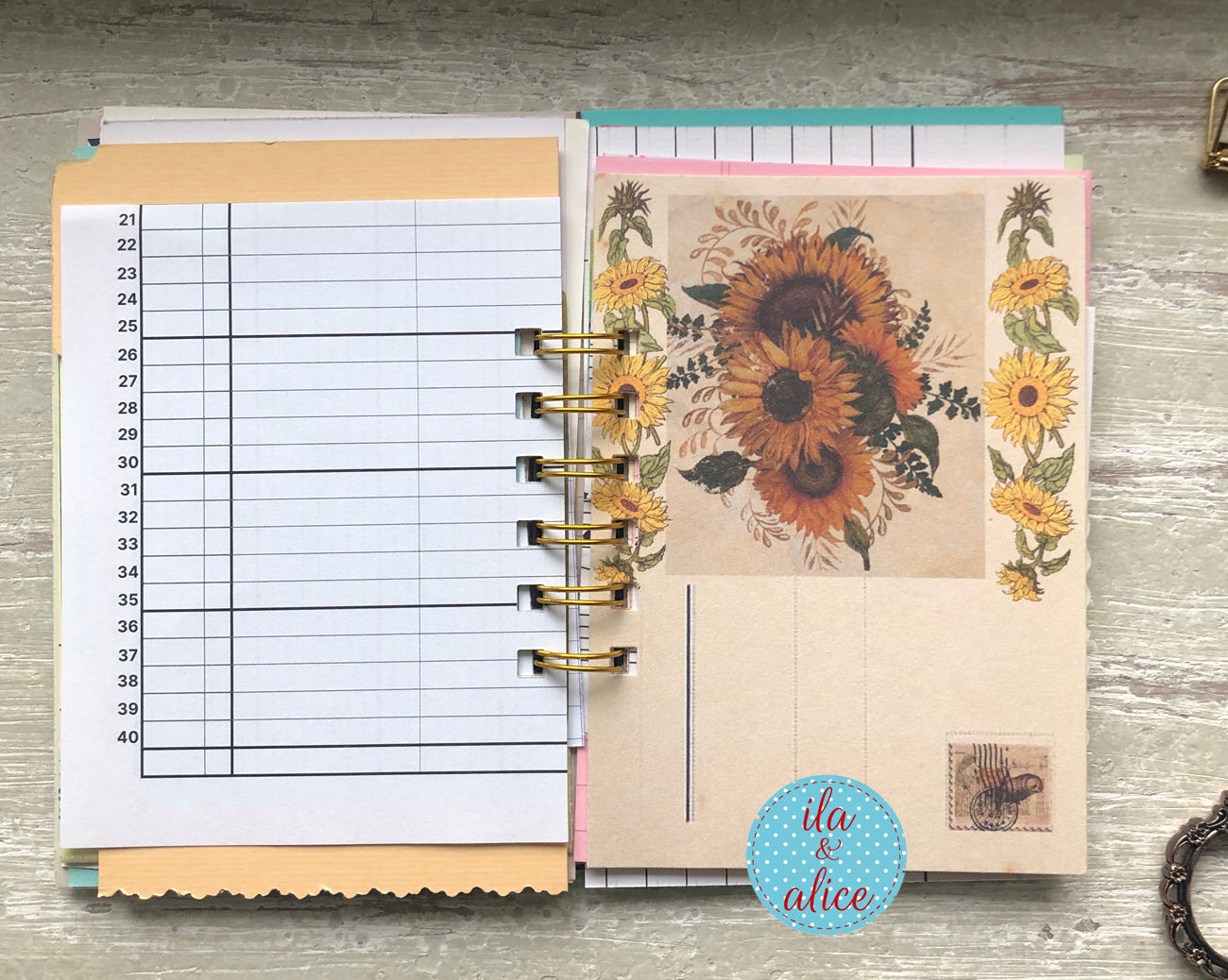 Planner with floral design on a wooden surface, featuring the brand 'ila & alice'.