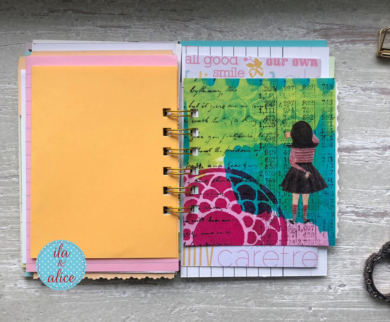 Planner with colorful cover and visible brand 'ila & alice' on a wooden surface