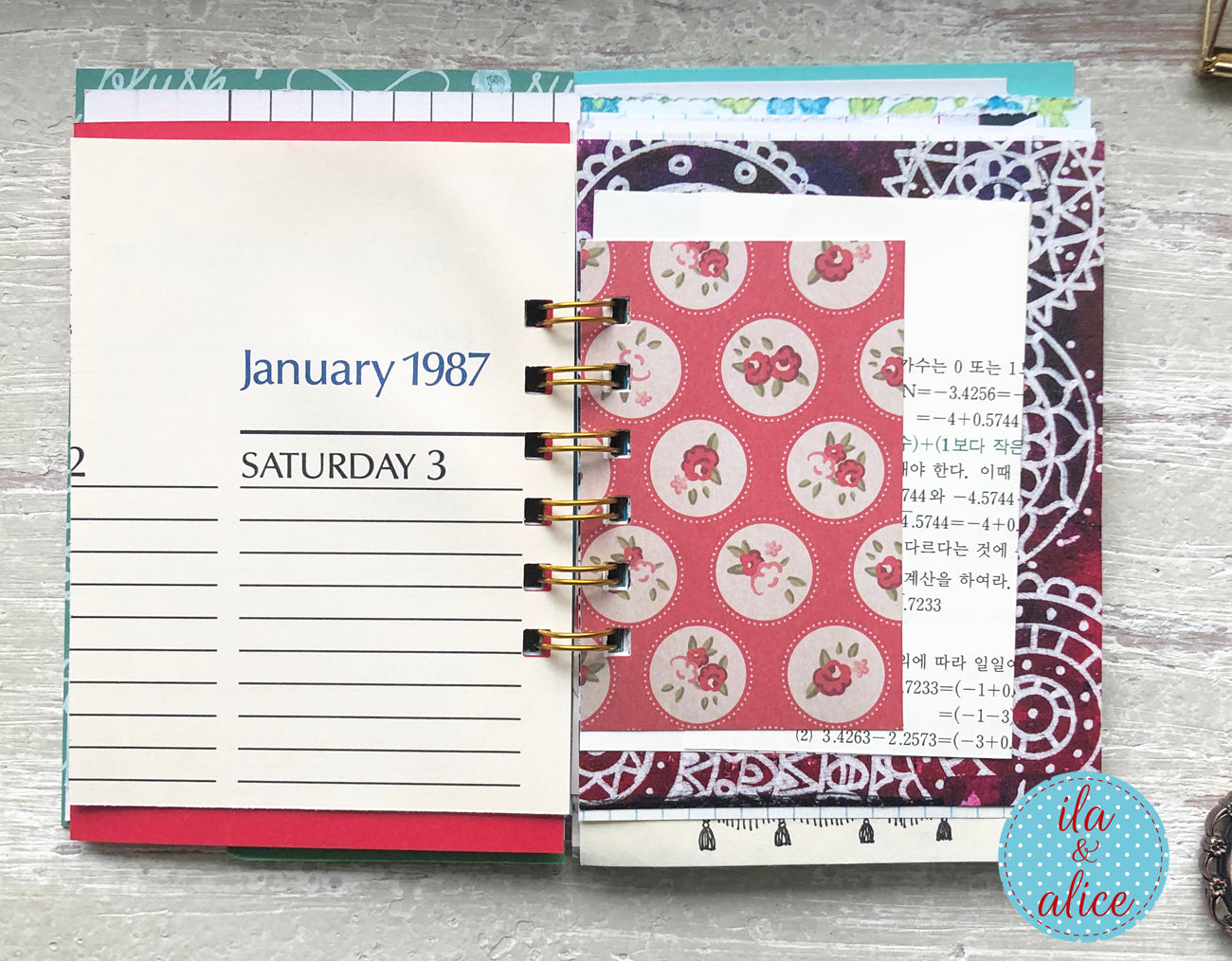 Planner with a floral design on a wooden surface, featuring the brand 'ila & alice'.